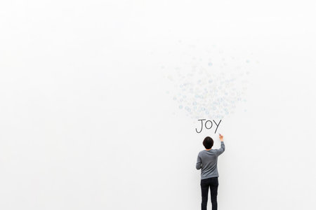 A man draws the word Joy on a wall with bubbles. Space for textの素材