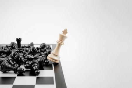 The white king stands among the defeated black pieces. Space for textの素材