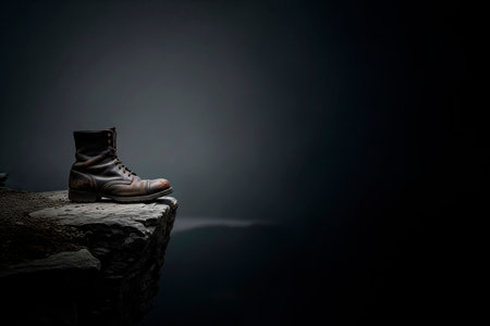 An old shoe stands on the edge of a cliff above the abyss. Space for textの素材