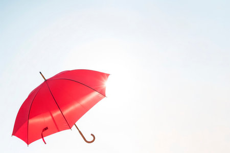 A red umbrella in a bright sunny sky. Space for textの素材