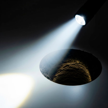 The beam of the flashlight illuminates a deep holeの素材
