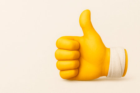 A yellow finger shows a like with a wristband. Space for textの素材