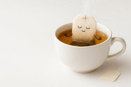 Tea bag in meditation pose in a cup with a drink. Space for textの素材