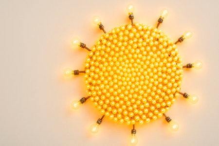 A chandelier made of many golden light bulbs in the shape of the sun. Space for textの素材