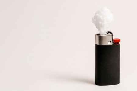 A lighter with a cloud of smoke instead of fire. Space for textの素材