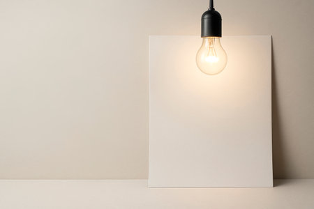 A light bulb illuminating a blank sheet of paper. Space for textの素材