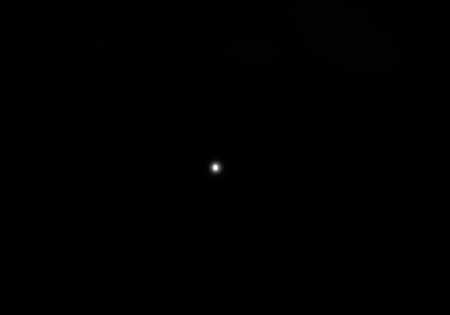 A lonely bright point of light in a dark spaceの素材