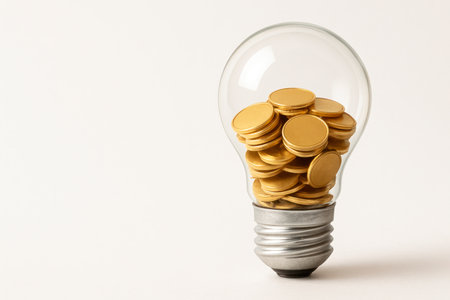 An electric light bulb filled with gold coins. Space for textの素材
