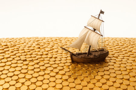 A sailing ship sails on a sea of gold coins. Space for textの素材
