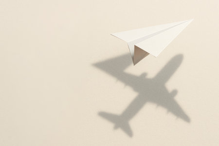 A paper airplane with the shadow of a real plane. Space for textの素材