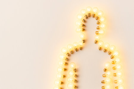 The figure of a man from light bulbs on a light background. Space for textの素材