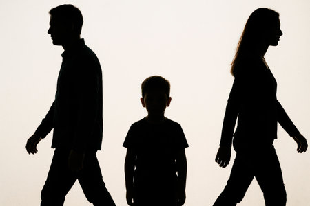 The silhouettes of a man and a woman diverge in different directions, a child between themの素材