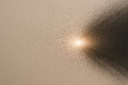 A stream of particles from a bright dot on a beige background. Space for textの素材