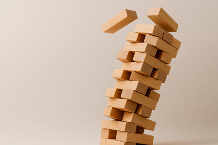 A tower made of wooden bars, losing its balance. Space for textの素材