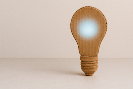 Cardboard light bulb glowing paper idea concept. Space for textの素材