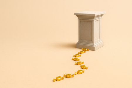 Golden candies lead to an empty pedestal. Space for textの素材