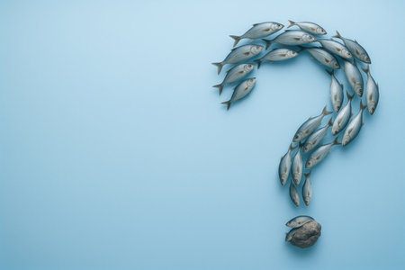 A school of fish in the shape of a question mark on a blue background. Space for textの素材