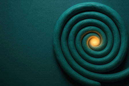 A spiral of green plasticine with a bright light in the center. Space for textの素材