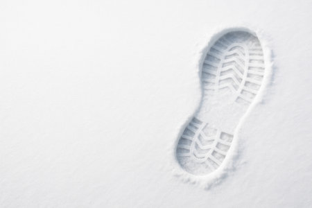 A boot footprint on fresh snow with empty space. Space for textの素材