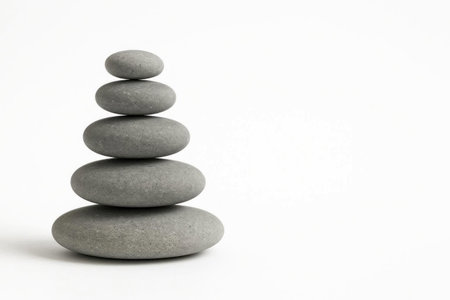 A tower of balanced gray stones on a white background. Space for textの素材