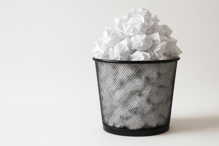 An overflowing basket of crumpled sheets of paper. Space for textの素材