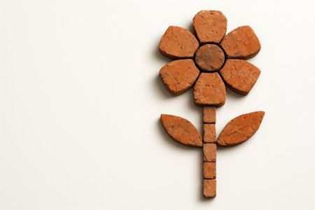 A flower made of brick fragments on a light background. Space for textの素材