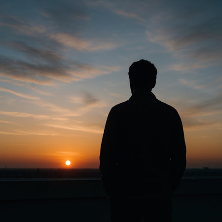 The silhouette of a lonely man looking at the sunset over the horizon. Space for textの素材