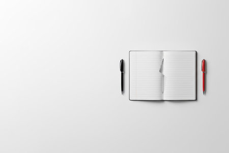 An open notebook with a torn page and two pens. Space for textの素材