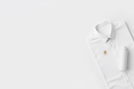 A white shirt with a stain and a bottle of laundry detergent. Space for textの素材