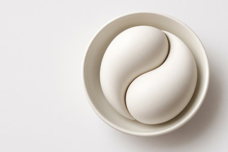 Two white abstract eggs folded in the shape of a perfect yang yang pattern. Space for textの素材