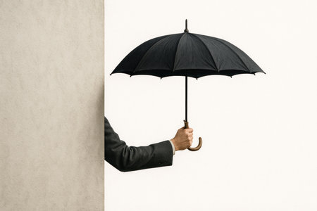 A hand with an umbrella appearing from behind the wall. Space for textの素材