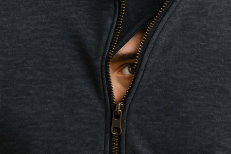 An eye peeking out of the open zipper of a sweaterの素材
