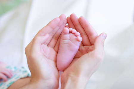 Father gently hold baby's leg in your hands