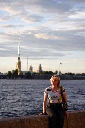 Girl sitting on canal border in Saint Petersburgの写真素材