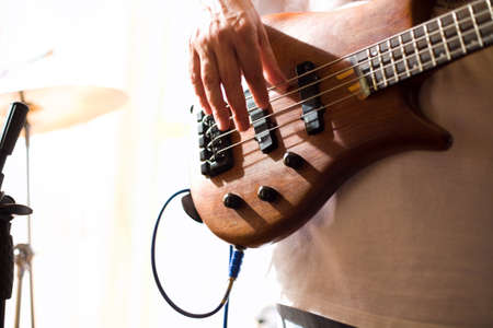 Musician play on bass guitar 
