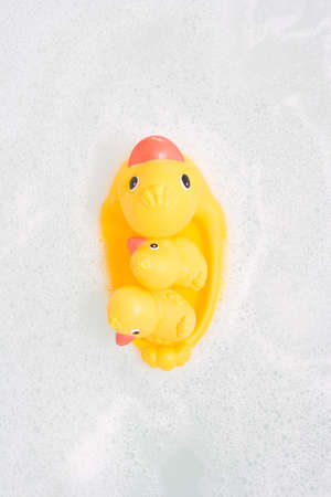 Three rubber ducks in foam water #2. Top viewの写真素材