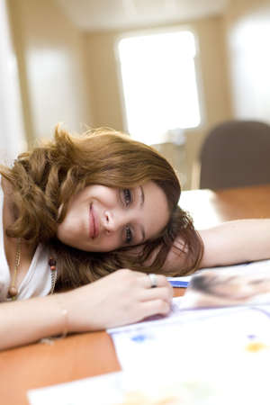 Attractive girl relax on a table after reading fashion magazineの写真素材