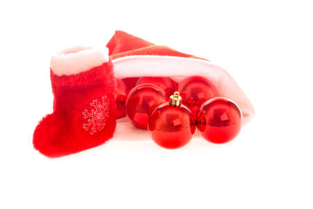 Santa hat and boot with red christmas balls isolated on white background. Light shadows under objectsの写真素材