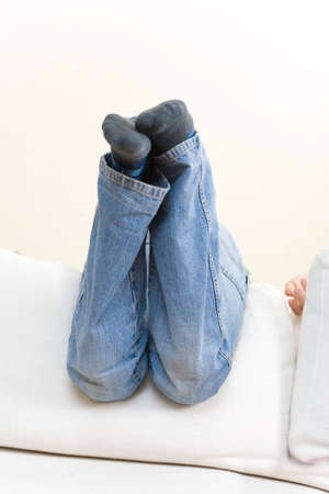 Teenager lie upside down on a sofa backrestの写真素材