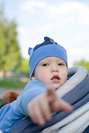  in sitting stroller pointing his finger right at youの写真素材