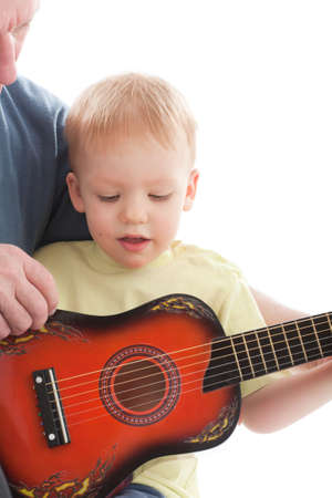 Grandfather teaching grandson play on acoustic guitar. Over white background