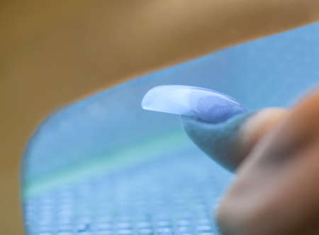 Stage of manicure: freezing of acrylic nail by ultraviolet lamp