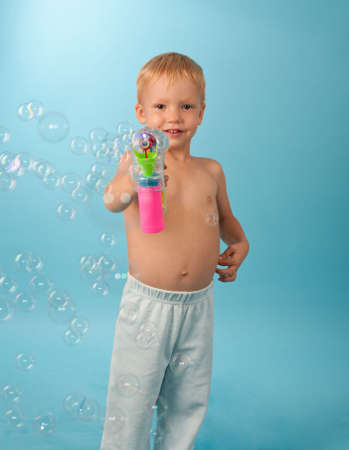 Portrait of little boy with pistol blowing soap bubbles