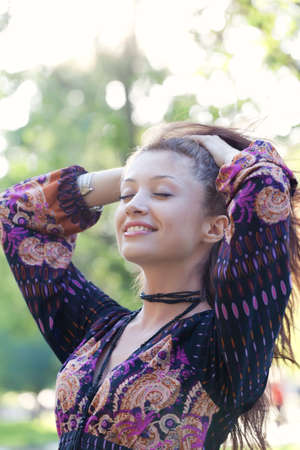 Young woman enjoys sun beams at spring parkの写真素材