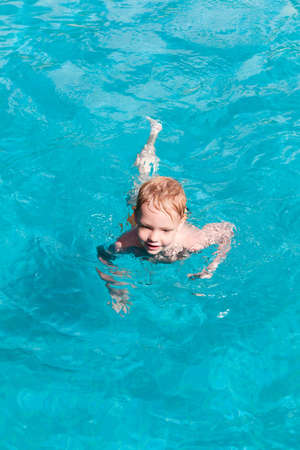 Young boy having fun in the indoor swimming poolの写真素材