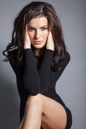 Portrait of brunette beautiful girl posing in black dress. Studio shotの写真素材