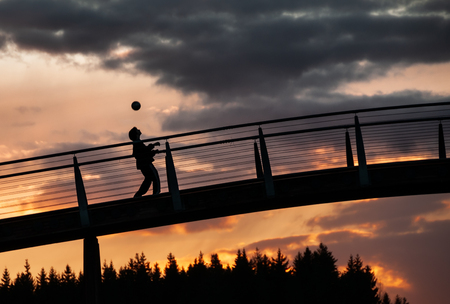 silhouette of a kid playing soccerの写真素材