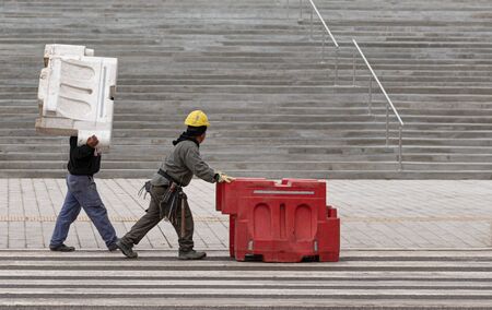 Workers carrying plastic parts for protection.の写真素材