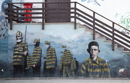 Ushuaia, Argentina - April 2 2012: Typical  architecture and a mural of famous prisoners of the mid-20th century.のeditorial素材