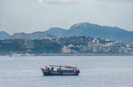 Rio de Janeiro, Brazil - August 17 2013: Boats and fishermen in front of rio de janeiro, next to the ferry terminal and Niteroi bridgeのeditorial素材